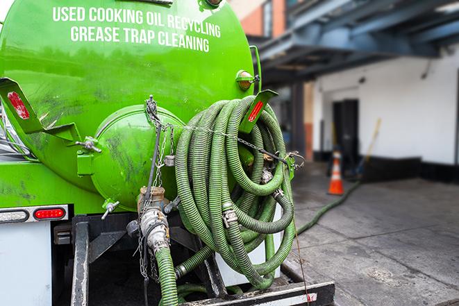 a technician pumping a grease trap in a commercial building in West Newbury MA